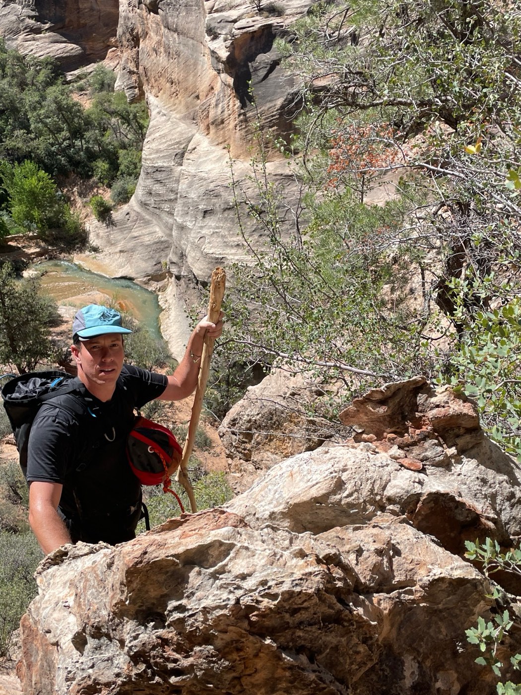 Scrambling out of a canyon with rope and stick